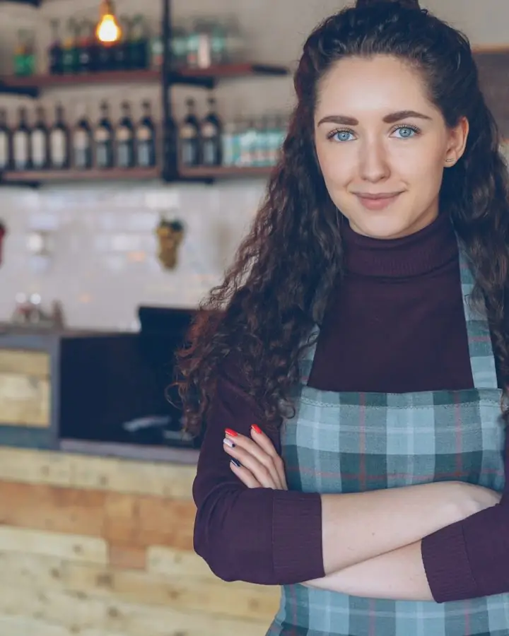A café owner standing in her shop