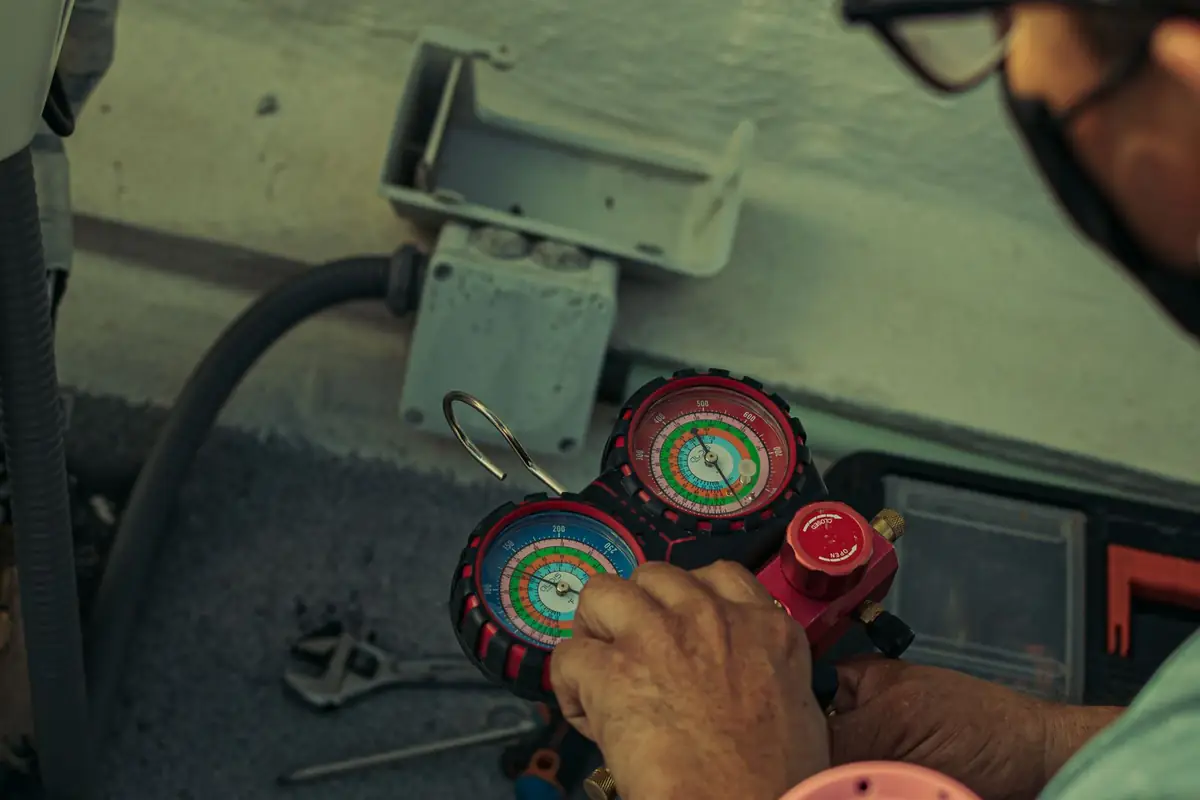 A heating technician reading a pressure gauge